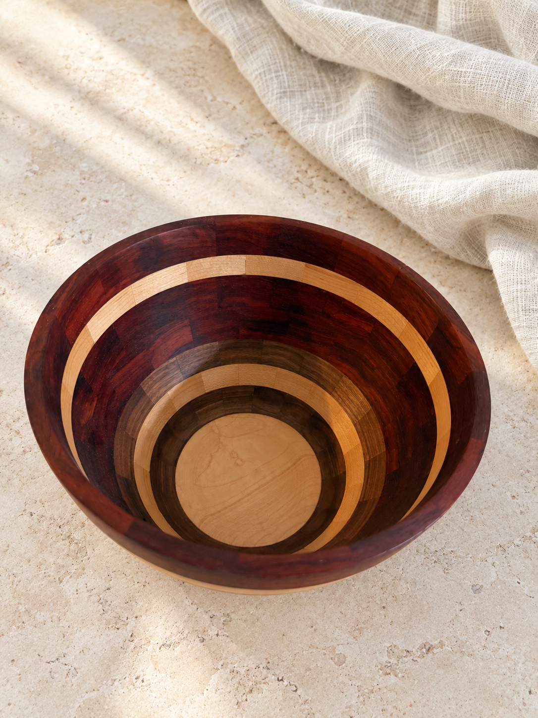 Interior of segmented padauk walnut and maple bowl on pale stone