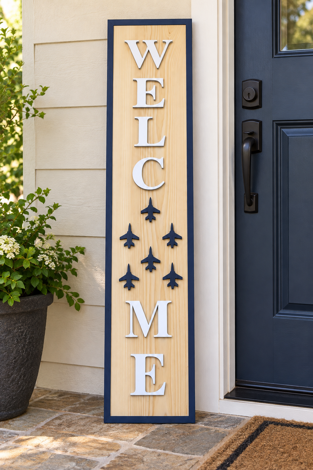 Four-foot handcrafted WELCOME porch leaner with six navy jet silhouettes beside a front door